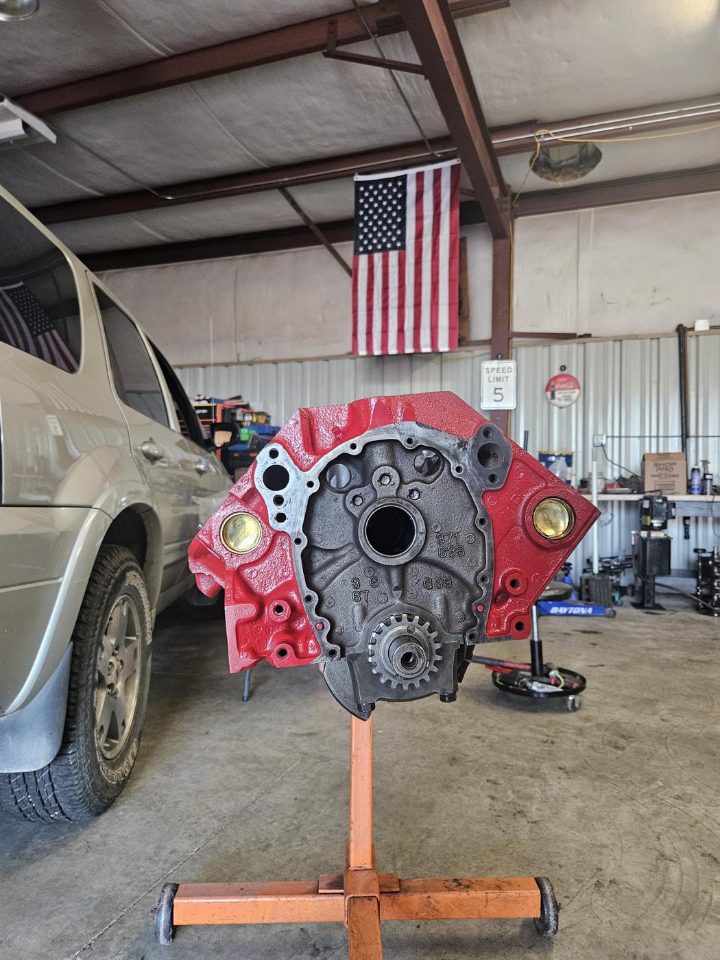 Freshly painted red engine block on a stand inside the shop